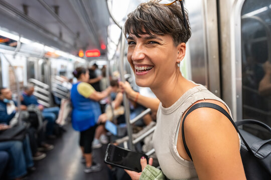 Young woman is smiling while commuting by subway in Manhattan