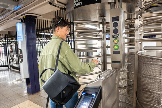 Tourist entering New York City subway station through turnstile