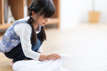 タオルを畳む女の子 © TAGSTOCK2