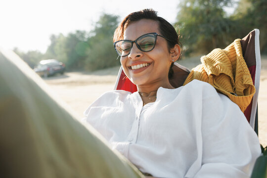 A cheerful woman in a foldable chair in the desert