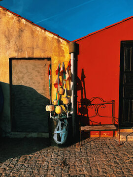 Rustic walls with fishing floats in vibrant sunlight.