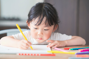 ダイニングテーブルでお絵かきをする子ども