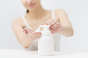 ボトルから泡を出す女性