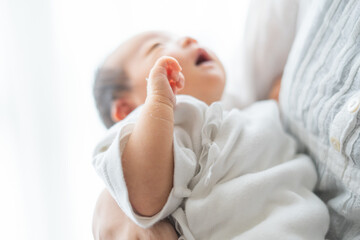 抱っこされる新生児（0歳0ヶ月）