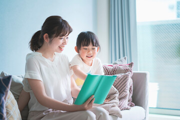 ソファに座って絵本を読む親子