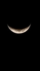 Beautiful crescent moon against a stark. black night sky, showcasing rich details of lunar texture....
