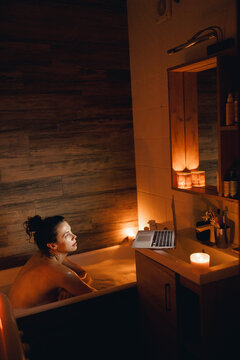 Portrait of a girl in foamy bathtub enjoying relax time