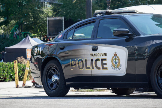Side view of a black and white Vancouver Police Department patrol car with 911 emergency markings and official emblem