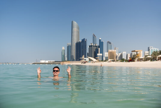 Happy man in the water in Abu Dhabi beach