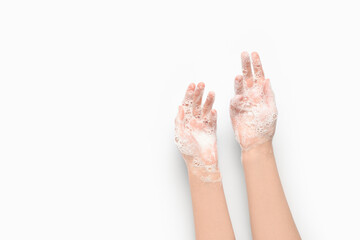 Woman washing hands with soap on white background