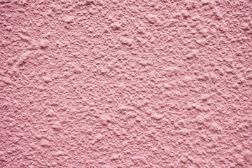 Pink mortar exterior wall of apartment. The texture of the pockmarked wall.