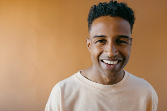 Studio portrait of young handsome man smiling at camera