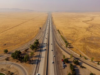 Aerial view of Interstate 5 highway running through Grapevine, California farmland. Cars and trucks...
