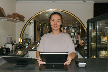 Owner of a cozy cafe assisting customers at the counter