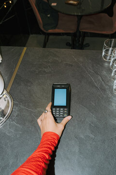 Coffee shop owner processing a payment at the counter