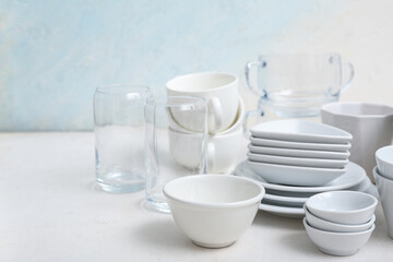 Beautiful tableware on table near light wall