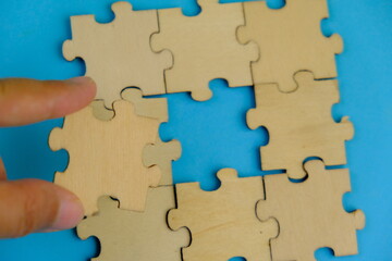 Frame of white puzzle elements on blue background. Business or educational concept. Selective...