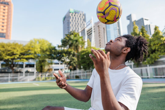 Sportsman throwing ball in mid-air while playing on field