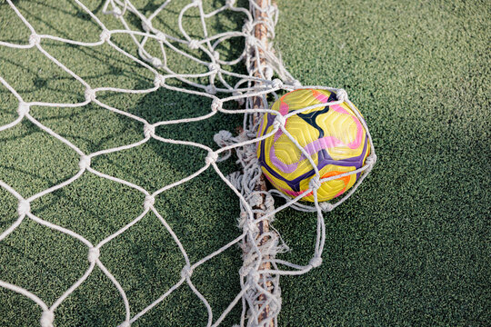 High angle view of soccer ball in net post of goal 