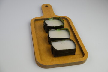 traditional Malaysian dessert called kuih tepung pelita or kuih tako. Coconut milk and flour prepared in banana leaves. Popular during fasting month Ramadan. isolated background
