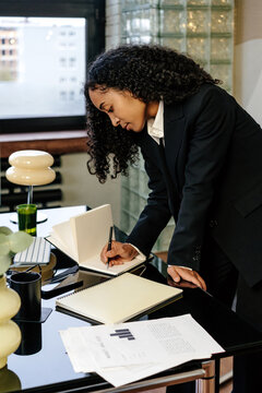 Focused businesswoman taking notes at office 