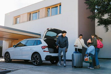 Family packing car at home outdoors