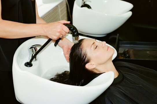 Relaxed woman while care hair procedure in salon.