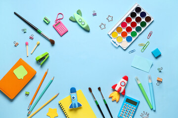 Frame made of different stationery and plasticine rockets on blue background. Top view