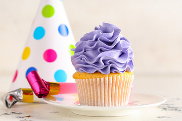 Sweet Birthday cupcake with party hat and whistle on white background