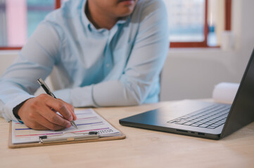 Executive Efficiency Businessman at Work using pen working with Documents data management, files and data management, bills expenses ,daily expenses, busy table with document and computer laptop