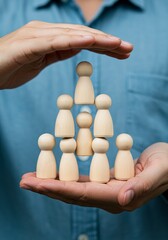 Hands holding a wooden hierarchical structure.