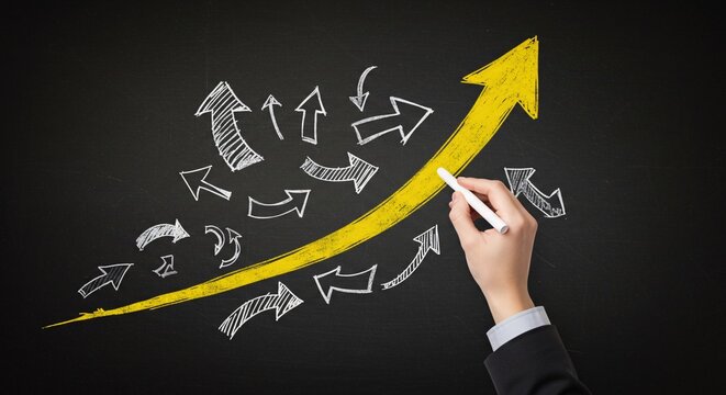 Hand drawing an upward arrow on board.