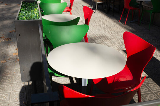 Red & green color plastic tables and chairs in urban city environment