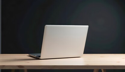 Sleek silver laptop placed on a wooden desk with a dark background, perfect for representing productivity, technology, and workspaces in a minimalist aesthetic. Ideal for business or creative contexts