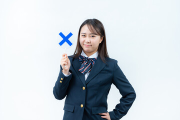 バツ印のプレートを持つ女子高校生