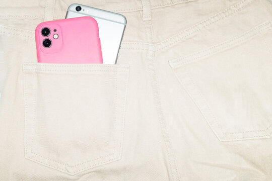 Multiple smartphones in pocket of denim jeans with hard direct flash