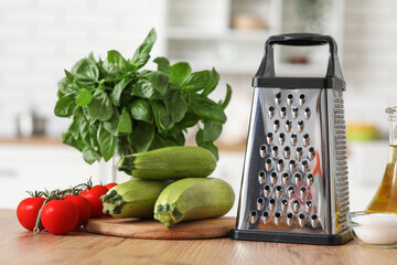 Grater and vegetables on table in kitchen
