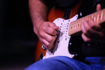 man playing electric guitar at the night