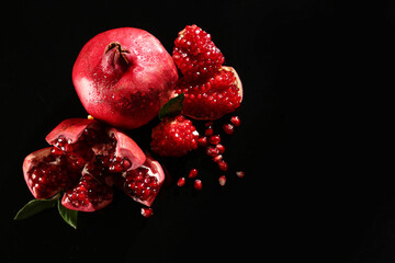 Fresh tasty pomegranates on black background