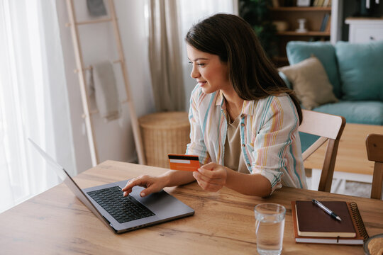 Young Woman Shopping Online Using Laptop and Credit Card