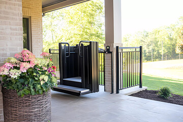 A vertical platform lift near a patio provides easy access, integrating modern engineering with thoughtful outdoor design for effortless mobility.