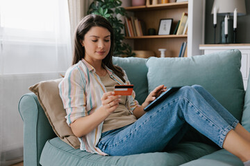 Young Woman Shopping Online Using a Digital Tablet and Credit Card
