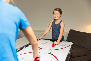 Mother and Daughter Playing Air Hockey in Basement Game Room