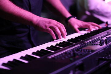 hands of a man playing the piano