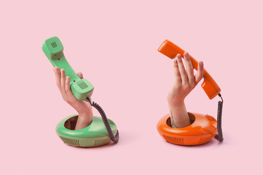 Vintage telephone handsets held by hands in studio