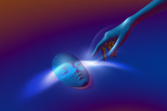 Illuminated hand reaching out to glowing face mask
