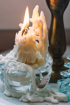 Unique candle with melting wax displayed on a table