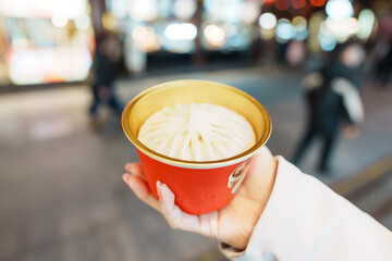 woman traveler visiting in Shanghai, China. Happy Female Tourist eating Xiaolongbao in Yuyuan Old...