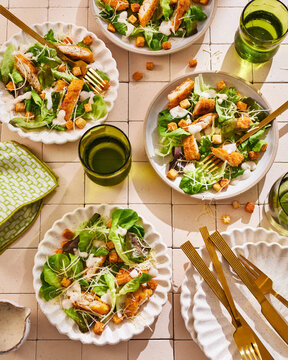 Elegant Table with Caesar Salads and Golden Utensils