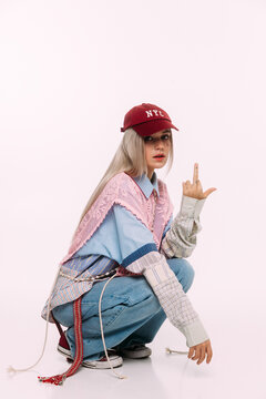 Fashionable young woman squats with a creative outfit